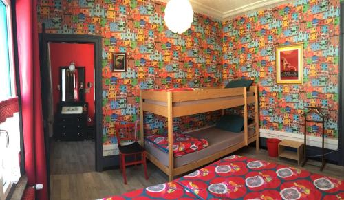 a bedroom with a bunk bed with a wall covered in lego tiles at La Maison Du Bulot in Fruges