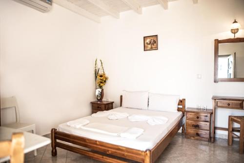 een slaapkamer met een bed, een ladekast en een spiegel bij Molos Studios in Naxos Chora