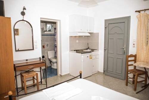 納克索喬拉的住宿－Molos Studios，厨房以及带水槽和桌子的浴室。