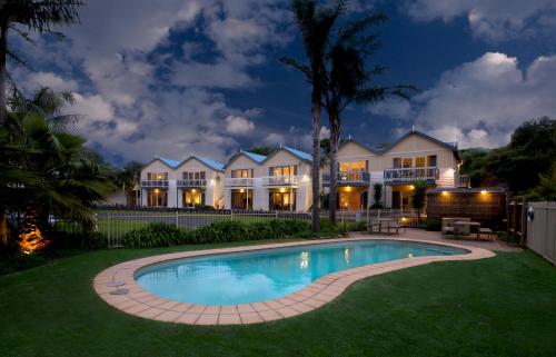 a large house with a swimming pool in the yard at Boathouse Resort Studios and Suites in Blairgowrie