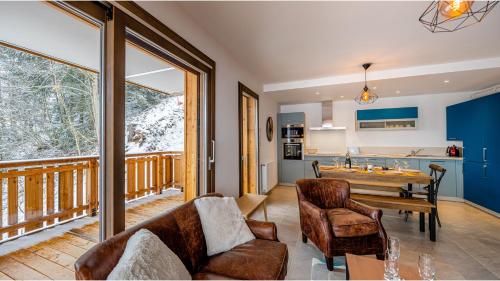 Il comprend un salon avec une table en bois et un balcon. dans l'établissement Les Freinets - Apt D102 - BO Immobilier - Châtel, à Châtel