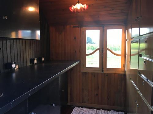 a kitchen with a counter top and a window at Gîte et Roulotte dans les Vosges in Remiremont