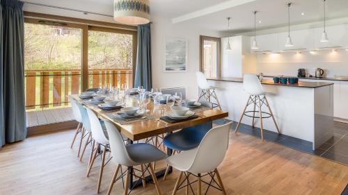 une salle à manger et une cuisine avec une grande table et des chaises dans l'établissement Les 4 Elements - Apt D102 - BO Immobilier, à Châtel