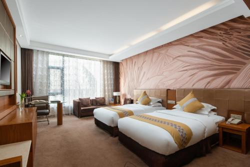 um quarto de hotel com duas camas e um sofá em Yun'an Huidu Hotel em Kunming