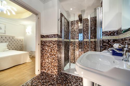La salle de bains est pourvue d'un lavabo, d'une douche et d'un lit. dans l'établissement Hotel Aurelia, à Milano Marittima