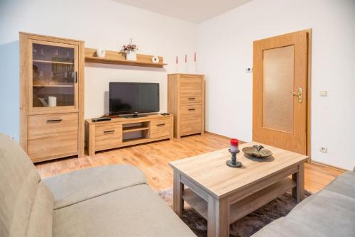 a living room with a couch and a tv and a table at Ferienwohnung Romy in Naumburg