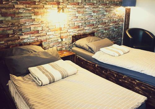 two beds in a room with a brick wall at Hotel Geismarburg in Göttingen