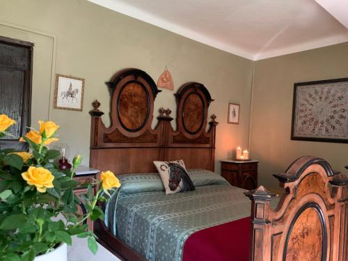 ein Schlafzimmer mit einem Bett mit einem Kopfteil aus Holz in der Unterkunft Locanda della Cavalleria in Trecastelli