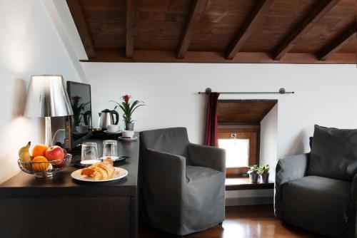 a room with a table with a bowl of fruit on it at Hotel Del Porto in Torri del Benaco