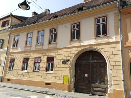 a building with a wooden door in a street at Jules Home in Sibiu