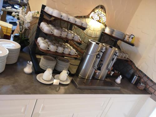 a kitchen counter with a coffee maker and some plates and shoes at Hotel Köln-Bonn in Bornheim