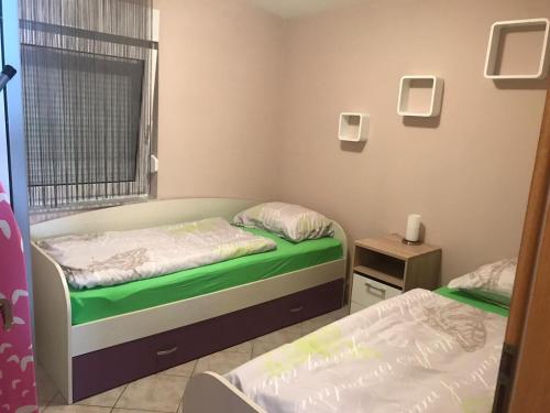 sypialnia z 2 łóżkami, oknem i spódnicą w obiekcie Apartman Petra 1 w mieście Vir