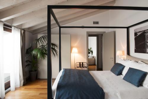 a bedroom with a canopy bed with blue pillows at Hotel Del Porto in Torri del Benaco