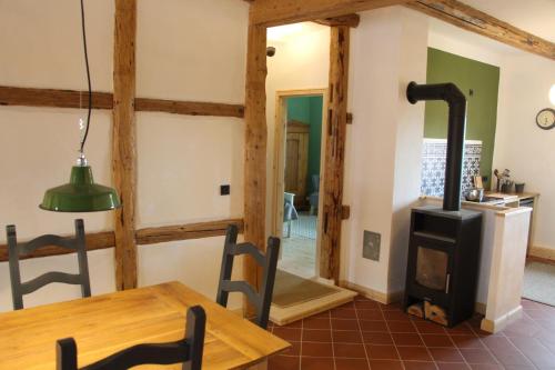 a kitchen and dining room with a wood stove at Magdalenenhof am Huywald - Kornboden mit Aussicht in Dingelstedt