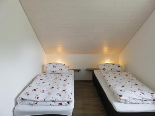 two beds in a small room with white walls at Ferienwohnung Seewaldstraße in Schluchsee