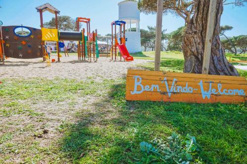 a park with a playground with a sign in the grass at Oasis Backpackers Hostel Sintra Surf in Sintra