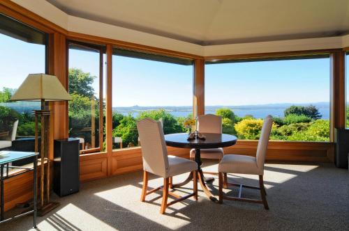 a dining room with a table and chairs and large windows at Lake Taupo Lodge in Taupo