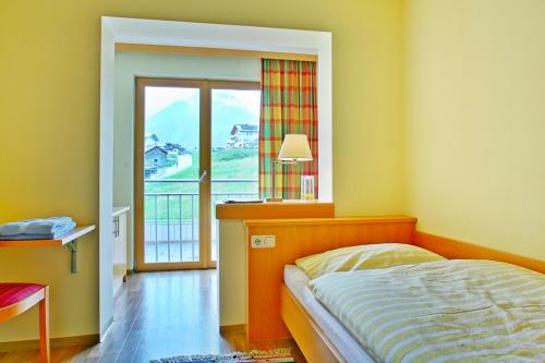 um quarto com uma cama e uma janela com vista em Der Lecher em Lech am Arlberg