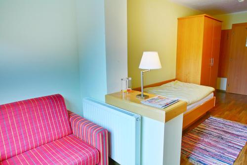 um quarto com um sofá, uma cama e uma cadeira em Der Lecher em Lech am Arlberg