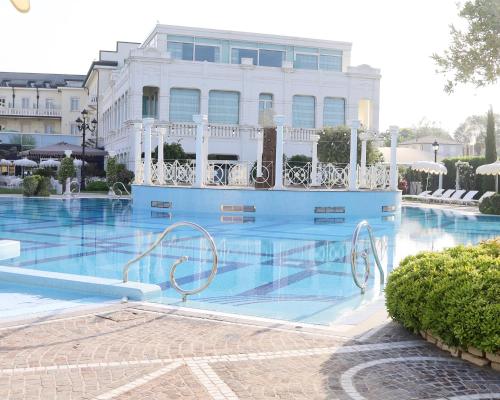 a swimming pool in front of a building at Grand Hotel Da Vinci in Cesenatico
