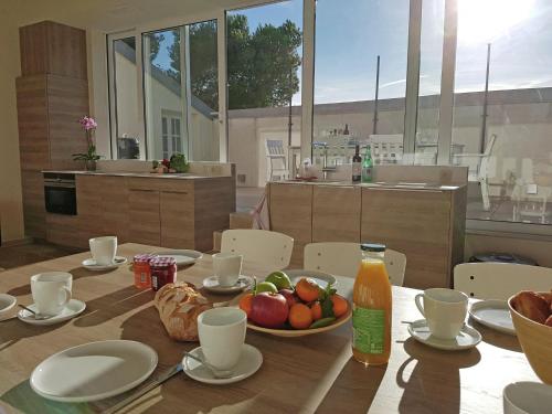 - une table avec un bol de fruits et une bouteille de jus dans l'établissement Apartment in Villesèque with Pool & Views, à Villesèque-des-Corbières