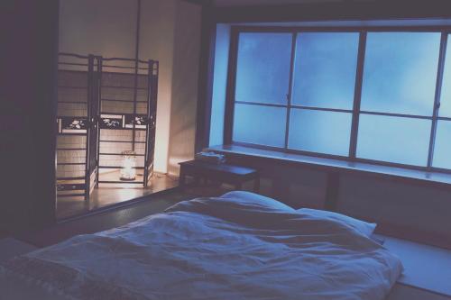 a bedroom with a bed and a window at おとまち 甘藍 Otomachi Kanran in Kure