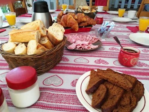 a table with a plate of bread and a basket of pastries at La Grange de Moisey in Marigny-lès-Reullée