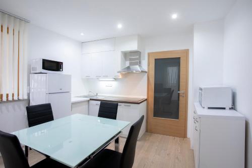 a white kitchen with a table and chairs at Apartment Arnika Kranjska Gora in Kranjska Gora