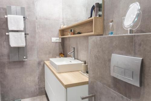 y baño con lavabo blanco y espejo. en Apartman Amore, en Baška Voda