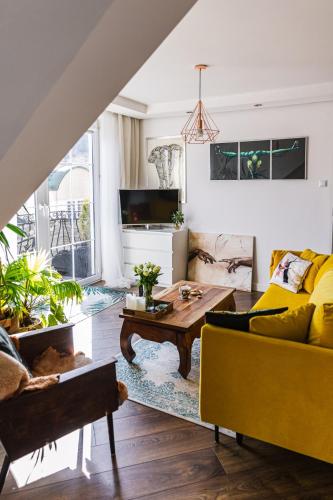 a living room with a yellow couch and a coffee table at Apartament Dobre Miejsce in Ustrzyki Dolne