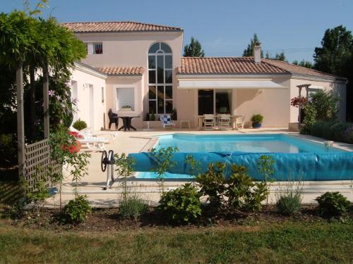 Villa con piscina frente a una casa en Chambre d'Hôtes Le Moulin, en Bessines