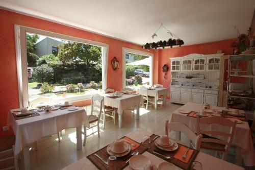 a dining room with white tables and a large window at Posada los Trastolillos in El Tejo