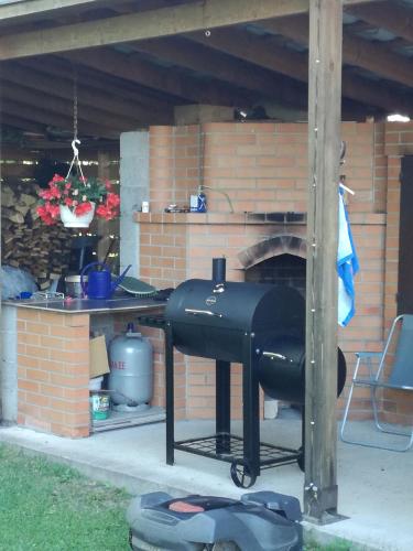 a grill in a patio with a brick fireplace at Villa River Rose in Jõesuu