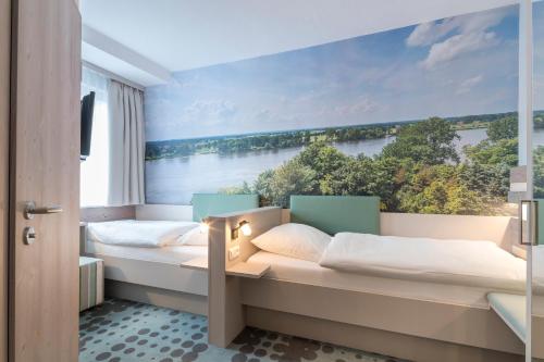 a bedroom with two beds with a view of a river at Hotel Bellevue in Lauenburg
