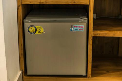 a gray refrigerator in a cabinet with a shelf at Esty House in Ubud
