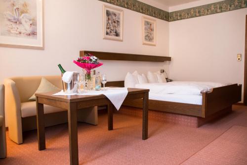 a hotel room with a bed and a table with flowers at Hotel Rheingraf in Kamp-Bornhofen