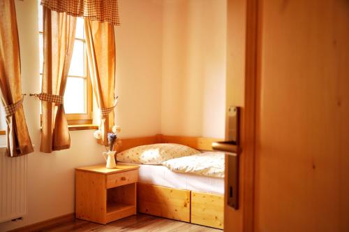 a small bedroom with a bed and a window at Penzión Uhliská a Depandance Gazdovský dom in Nemšová