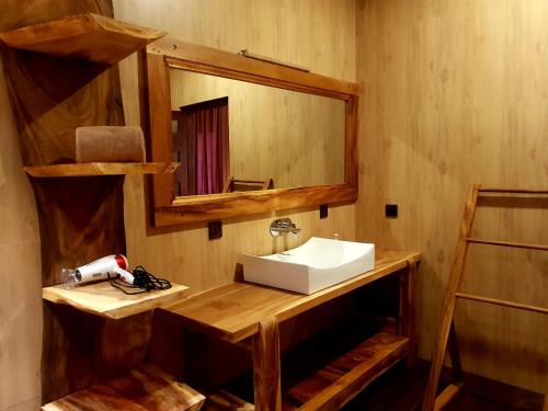 
a bathroom with a wooden cabinet and a mirror at Leisure Dream Inn in Ella
