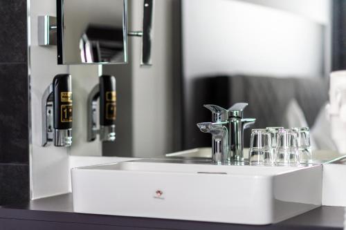 a bathroom sink with a faucet and a mirror at Hotel Fohnsdorf in Fohnsdorf