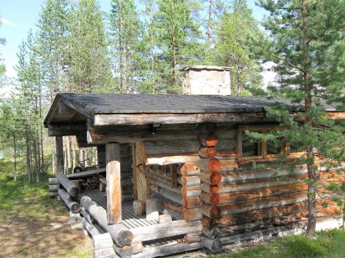 une cabane en rondins au milieu d'une forêt dans l'établissement Cabin at Huskies Farm, à Inari