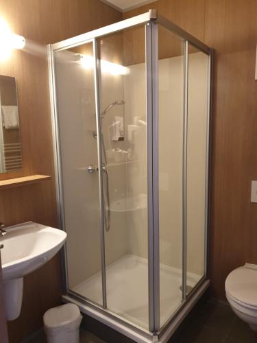 a glass shower in a bathroom with a toilet at FairSleep Motel Hainburg in Hainburg an der Donau