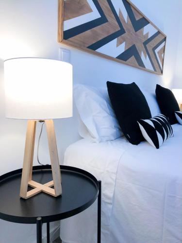 a table with a lamp next to a bed at Casa dos Castelos in Évora