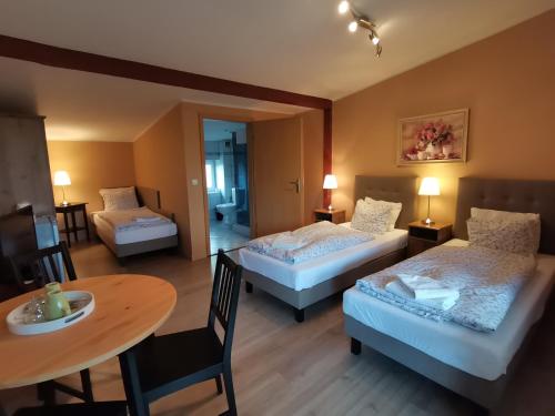 a room with two beds and a table and a dining room at W Starym Ogrodnictwie in Przyszowice