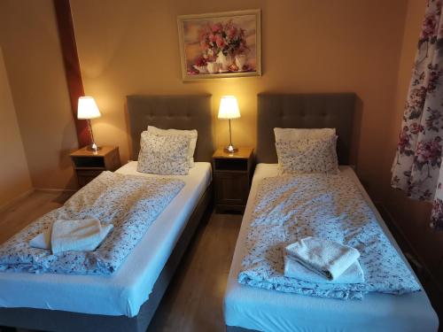 two beds sitting next to each other in a room at W Starym Ogrodnictwie in Przyszowice