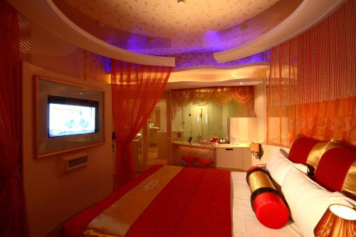 a bedroom with a large bed with a tv on it at 陽明旅館 in Kaohsiung