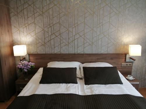 a bedroom with a large bed with two pillows at Hotel Zakliki in Kraków