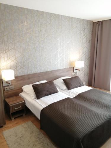 a bedroom with a large bed and two lamps at Hotel Zakliki in Kraków