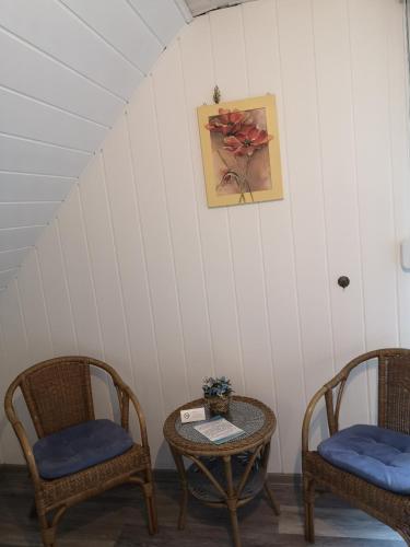 a room with two chairs and a table and a picture at Gästehaus Spies in Bullay