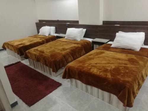 a group of three beds in a room at AL ASAFRA DAHAB - families only in Alexandria