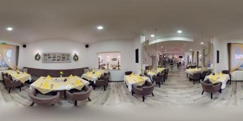 un restaurante con mesas y sillas en una habitación en Pension & Restaurant La Amalia en Bad Sauerbrunn
